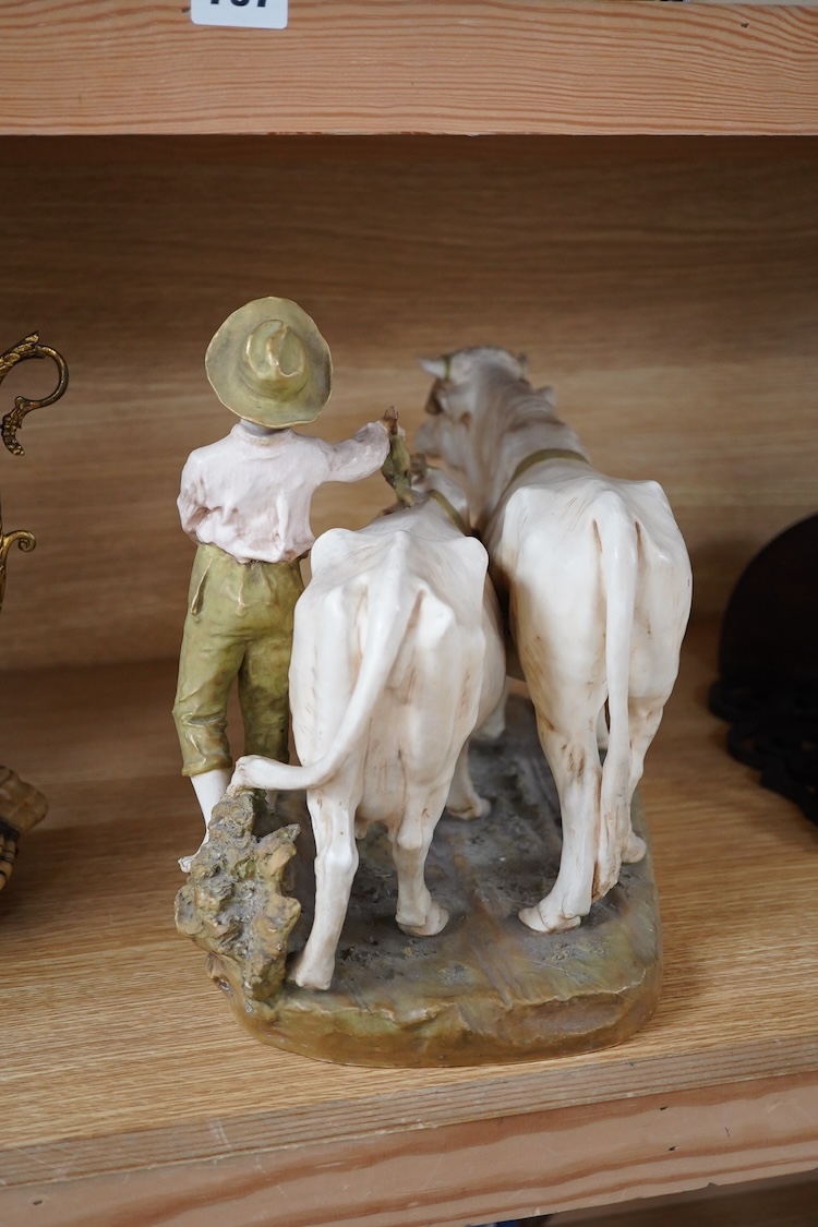 A large Royal Dux porcelain group of a pair oxen with a farm hand, pink triangle mark. 38cm wide